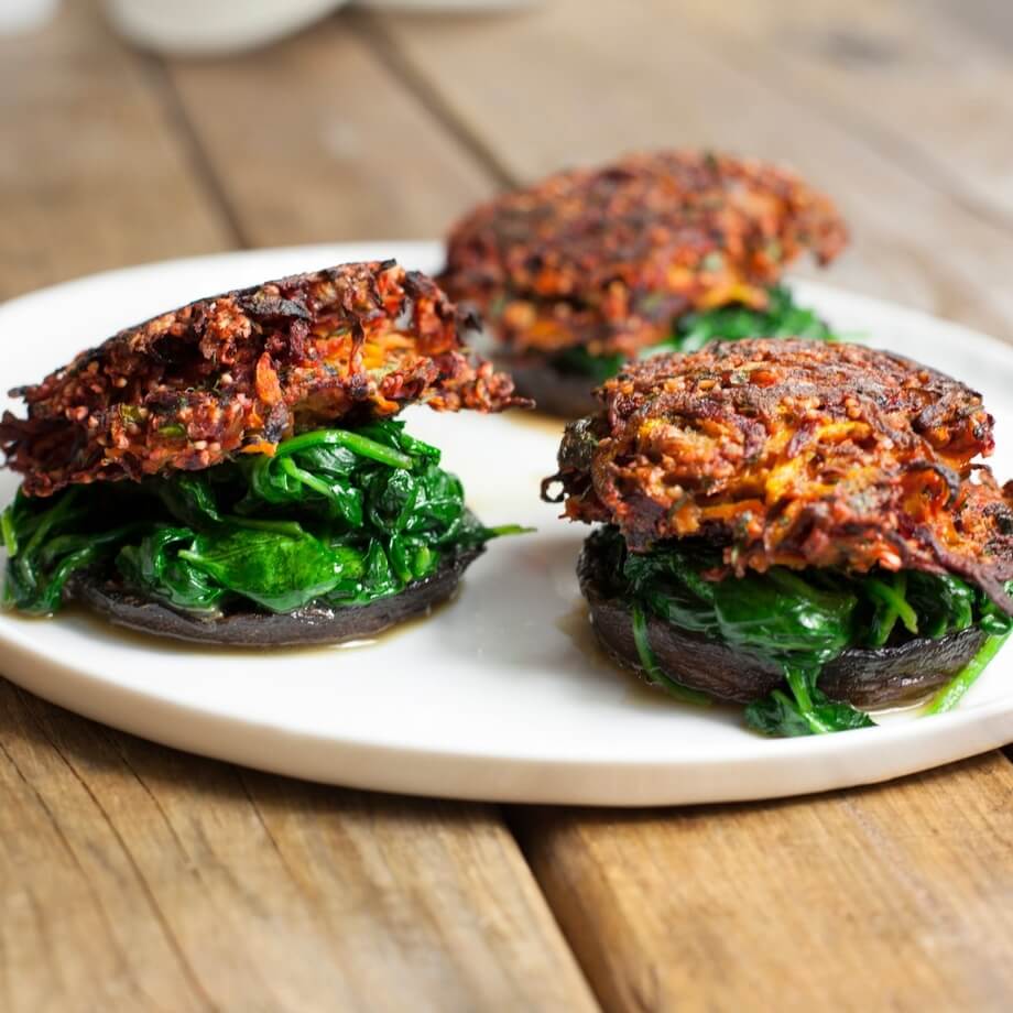 Beetroot and carrot burgers on wilted spinach and roasted / Riverford