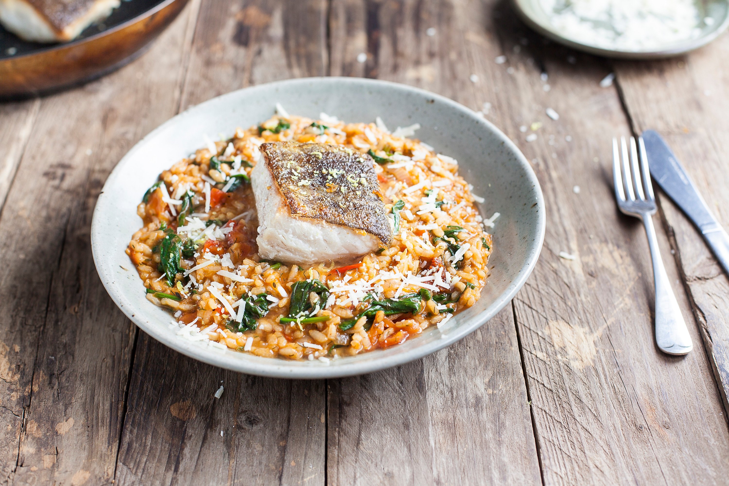 Spinach and tomato risotto with crispy pan-fried fish / Riverford